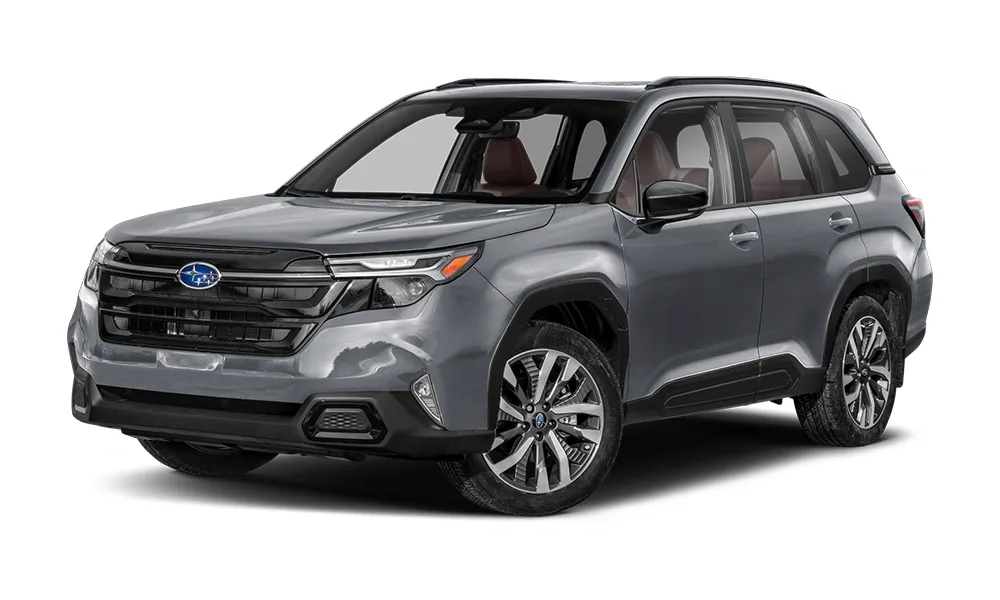 2025 Subaru Forester in a grey metallic finish, shown from a front-side angle. The SUV features a prominent grille with the Subaru emblem, LED headlights, black cladding on the wheel arches, and a sturdy, adventure-ready stance ideal for families and outdoor enthusiasts.